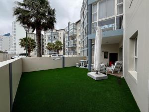 a balcony with green grass on a building at La Palma Villa 8 in Mossel Bay