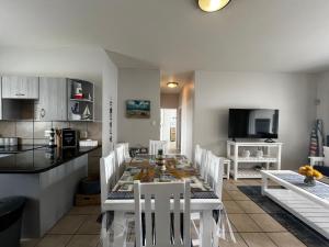 a kitchen and dining room with a table and chairs at La Palma Villa 8 in Mossel Bay