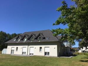 a large white building with a black roof at Haus Sonne - Whg 08 in Thiessow