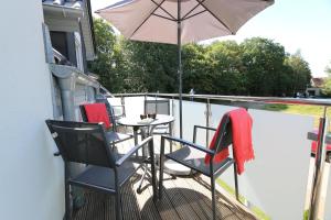 a patio with a table and chairs and an umbrella at Haus Sonne - Whg 08 in Thiessow