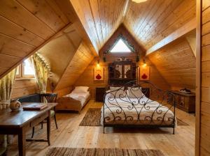 a bedroom in a log cabin with a bed and a table at Golden Tatra Chalet - Fireplace, Sauna & Garden in Zakopane