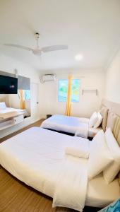 a bedroom with two beds and a couch at VelaaOlhu - Turtle Hive Thulusdhoo in Thulusdhoo