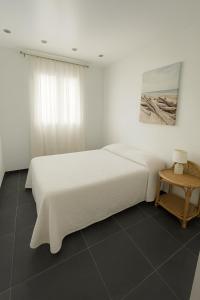 a white bedroom with a bed and a table at Holidays in Sainte-Maxime