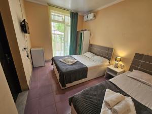 a small room with two beds and a window at Imeri Hotel in Ureki