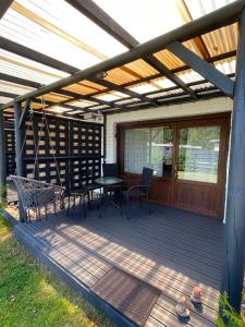 a patio with a table and chairs on a deck at Pāvilostas Piparmētras in Pāvilosta