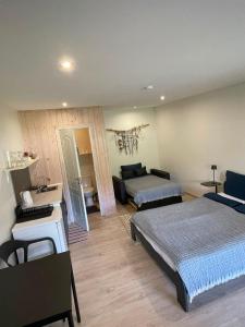 a bedroom with two beds and a living room at Pāvilostas Piparmētras in Pāvilosta