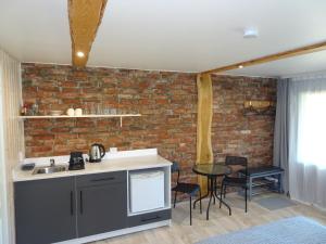 a kitchen with a brick wall and a table and chairs at Pāvilostas Piparmētras in Pāvilosta