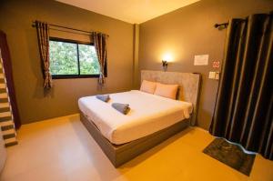 a bedroom with a bed in a room with a window at The Rest Hotel in Ko Larn