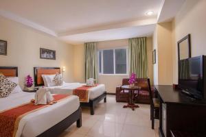 a hotel room with two beds and a flat screen tv at Wind Holiday Hotel in Phnom Penh