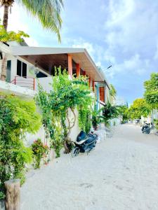 a motorcycle parked next to a building on the beach at VelaaOlhu - Turtle Hive Thulusdhoo in Thulusdhoo