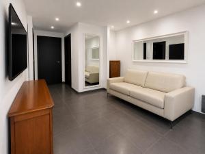a living room with a white couch and a television at Holidays in Sainte-Maxime