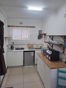 a kitchen with white cabinets and a counter top at The haven in George