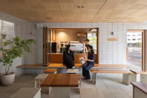 two women sitting on benches in a coffee shop at Long Weekend Haus in Seoul