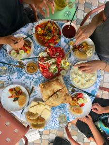 a group of people sitting around a table with plates of food at Zhorzholiani House - Betkili in Lakhiri +12 photos