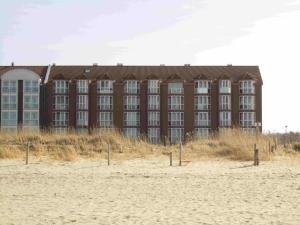 a large building on the beach next to the sand at Horizont-Wohnung-3 in Cuxhaven