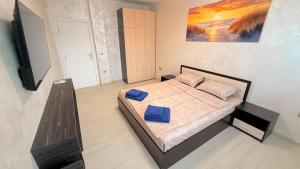 a bedroom with a bed and a flat screen tv at Moni Sunset Apartment Balchik in Balchik +10 photos