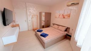 a bedroom with a bed with two blue pillows on it at Moni Sunset Apartment Balchik in Balchik