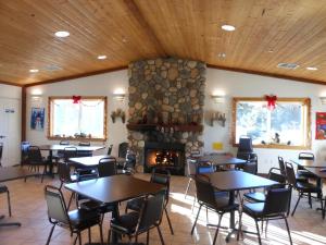un restaurante con mesas y sillas y una chimenea en Oakzanita Springs Camping Resort Cottage 3, en Descanso