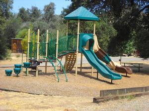 a playground with a slide in a park at Oakzanita Springs Camping Resort Cottage 3 in Descanso