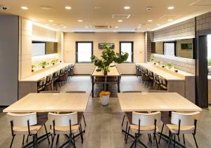 a restaurant with tables and chairs and plants at Super Hotel Namba Nipponbashi in Osaka