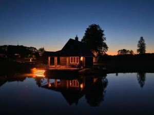 a cabin in the middle of a lake at night at Milžinai Retreat in Zarasai +13 photos