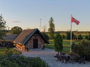 a building with a flag and a flag pole at Milžinai Retreat in Zarasai