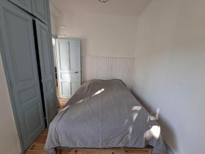 a bedroom with a bed with a gray comforter at Appartement avec jardin privé à 5 min du Cheylard & Dolce Via - Vacances natures, vélo & randos in Accons