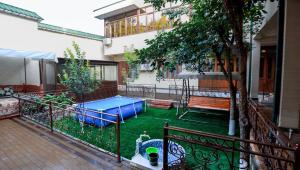 a small backyard with a trampoline in the yard at Family Hotel in Khujand +12 photos