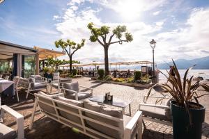 a restaurant with chairs and tables and a view of the ocean at Hotel Del Porto in Torri del Benaco