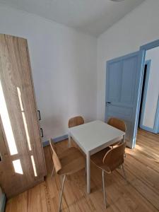 a white table and chairs in a room at Appartement avec jardin privé à 5 min du Cheylard & Dolce Via - Vacances natures, vélo & randos in Accons