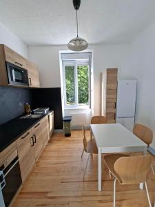 a kitchen with a table and a white table and chairs at Appartement avec jardin privé à 5 min du Cheylard & Dolce Via - Vacances natures, vélo & randos in Accons