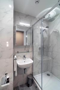 a white bathroom with a sink and a shower at Stoneybatter Place in Dublin +14 photos