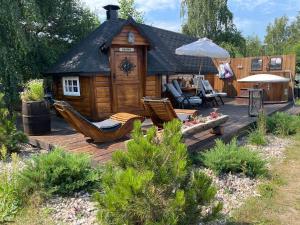 Eine Terrasse mit einer Hütte, Stühlen und einem Sonnenschirm in der Unterkunft Stativa Campo Gitano in Gaśno