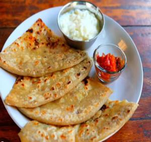a white plate with eight tortillas and a bowl of sauce at Hotel Vishal in Buxar