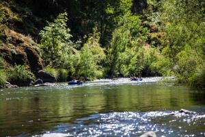 a group of people tubing down a river at Russian River Camping Resort One-Bedroom Cabin 2 in Cloverdale