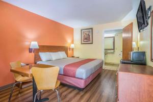 a hotel room with a large bed and a desk at Rodeway Inn & Suites in Lakeview