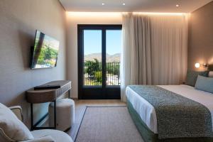 a hotel room with a bed and a sliding glass door at Hotel Delfinia in Mythimna