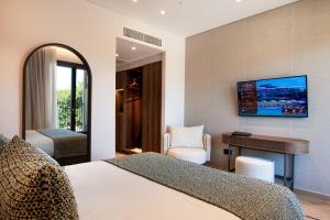 a hotel room with a bed and a desk and a television at Hotel Delfinia in Mythimna