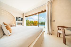 a bedroom with a bed and a large window at La Bastide des Rameaux - Boutique Hôtel & Spa in Callas +70 photos