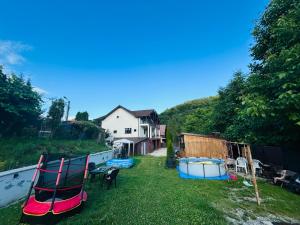 ein Hof mit zwei Gartenstühlen und einem Haus in der Unterkunft Vila Ema Râşnov in Râșnov
