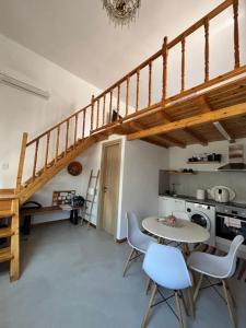 a kitchen with a staircase and a table and chairs at To Katinaki in Trikeri