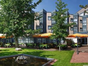 a courtyard with a fountain and tables and a building at Sunday Hotel Köln Brühl in Brühl