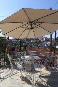 a patio with a table and chairs and an umbrella at To Katinaki in Trikeri