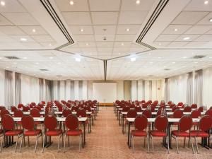 a conference room with tables and chairs and a whiteboard at Sunday Hotel Köln Brühl in Brühl