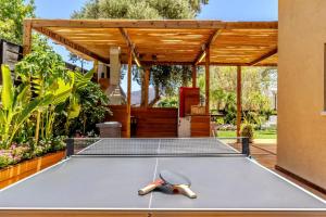 a ping pong table in a backyard with a pavilion at Villa Sun Bay in Eilat