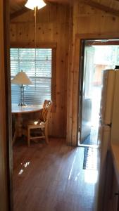 a dining room with a table and a refrigerator at Snowflower Camping Resort Cabin 4 in Emigrant Gap