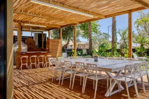 a long white table and chairs on a deck at Villa Sun Bay in Eilat