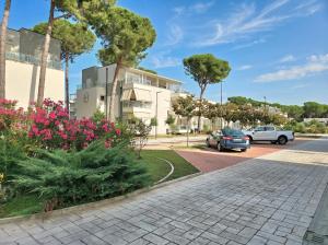 a street with cars parked in front of a building at Sunny Beach Penthouse - 216 in Draç