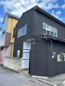 a black house with a white door at HOTEl MOTO in Oshima