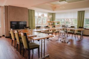 a dining room with tables and chairs and windows at Maiers Johanniterbad Ringhotel Rottweil in Rottweil